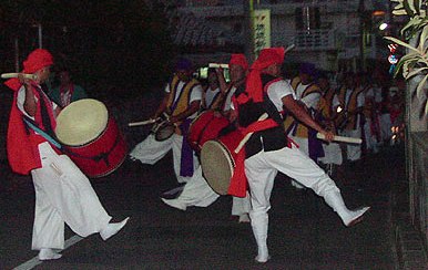 Groups of musicians and dancers make their way through the community at night during the Bon festival.